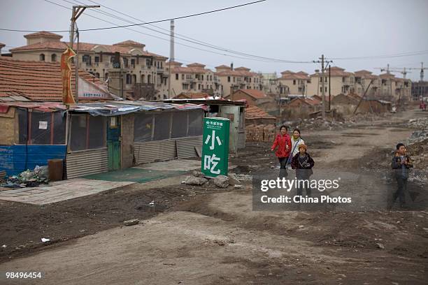 Children walk through a shanty town near new construction on April 15, 2010 in Changchun, Jilin Province, China. Many low-income residents cannot...