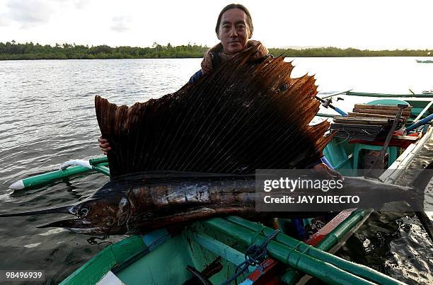 Filipino angler Gary Manas poses with a sailfish he caught in the fishing village of Pilar on Siargao Island, southern Philippines on April 16, 2010....