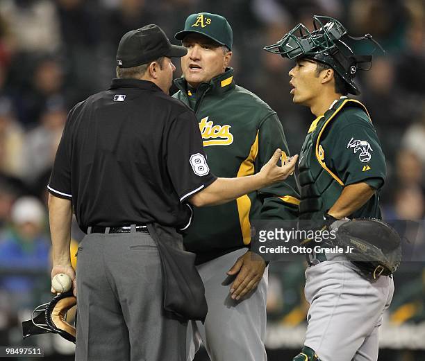 Manager Bob Geren and catcher Kurt Suzuki of the Oakland Athletics argue with home plate umpire Doug Eddings during the game against the Seattle...