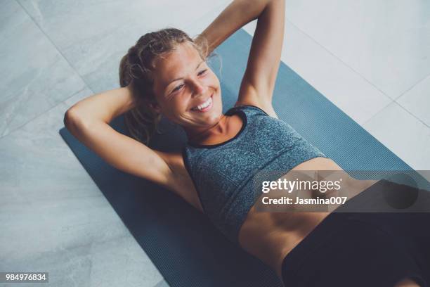 donna sportiva che fa esercizio fisico in palestra - sit up foto e immagini stock