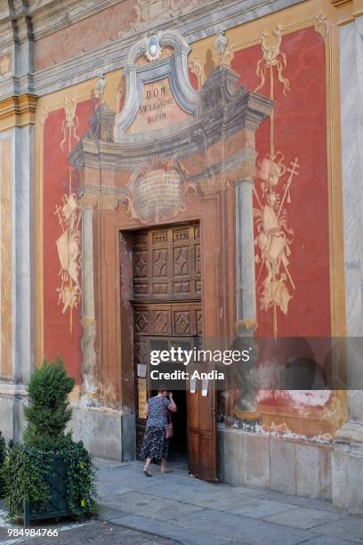 Saluzzo in the province of Cuneo, Piedmont region. Woman entering St Nicholas' Church .