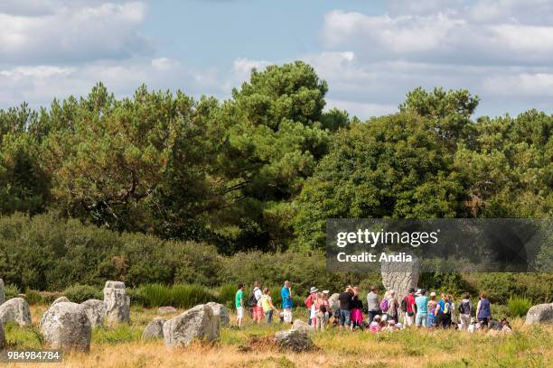 Group of vacationers on a guided tour through the Menec alignments in Carnac.