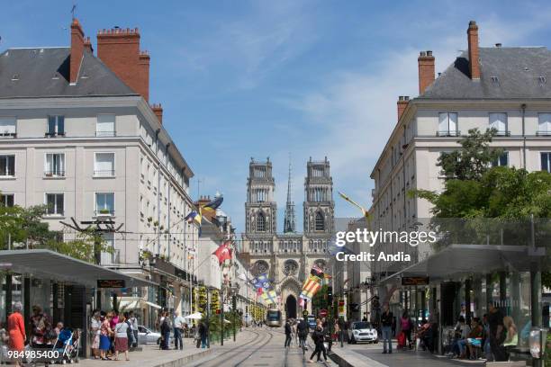 Orleans : real estate, buildings in the street 'rue Jeanne d'Arc', in the city center. Building facade, pedestrians, tram rails and Cathedral of...