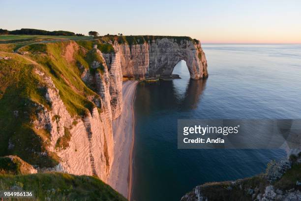Etretat , town along the 'Cote d'Albatre' , in the area called 'pays de Caux'. The 'Manneporte' sea stack at nightfall.