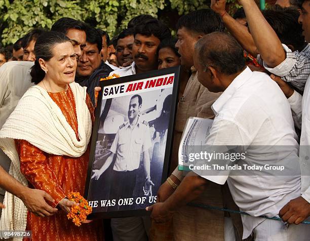 People present the photograph of Rajiv Gandhi to Sonia Gandhi in New Delhi on Wednesday, April 14, 2010.