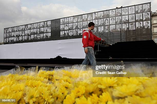 Worker directs preparations under a screen displaying photographs of the 96 people killed in the recent Polish presidential plane crash in Smolensk...