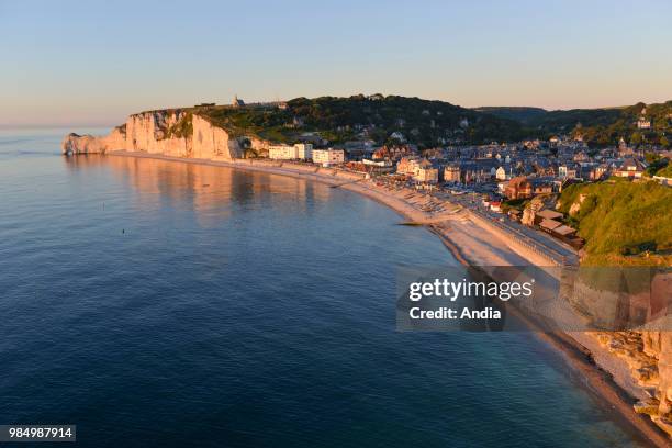 Etretat , town along the 'Cote d'Albatre' , in the area called 'pays de Caux'. Pebble beach wit the city and the cliffs at nightfall.