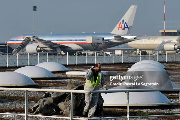 Man works as planes are grounded in the background at the Charles-de-Gaulle airport in Roissy on April 16, 2010 in Paris, France. Charles-de- Gaulle...