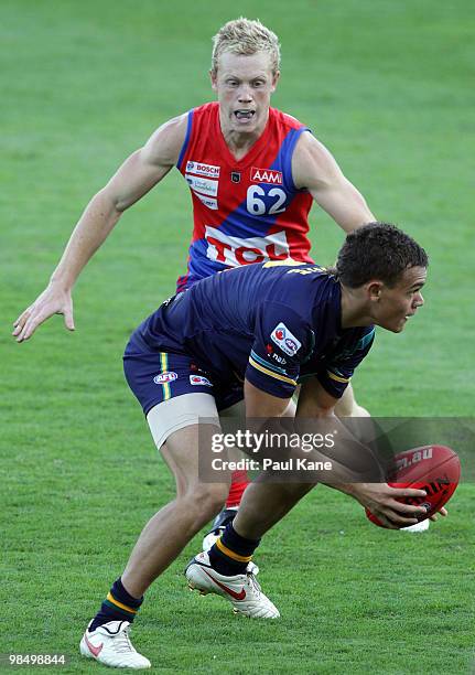 Gerald Ugle of the AIS looks to handball before being tackled by Trent Batterham of West Perth during the trial match between the AIS AFL Academy and...