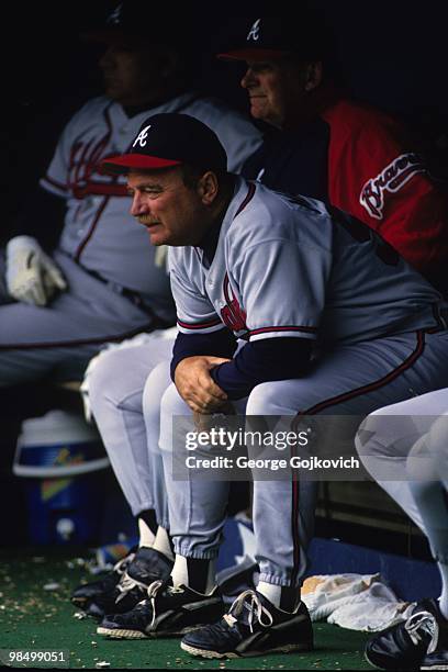 Pitching coach Leo Mazzone of the Atlanta Braves looks on from the dugout while sitting next to manager Bobby Cox during a Major League Baseball game...