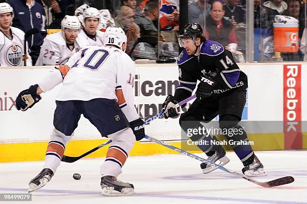 Justin Williams of the Los Angeles Kings skates with the puck against Shawn Horcoff of the Edmonton Oilers on April 10, 2010 at Staples Center in Los...