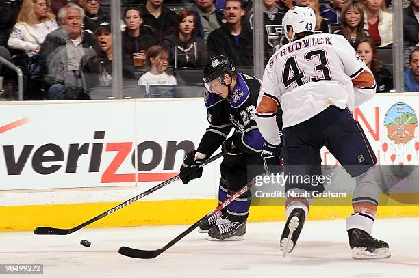 Dustin Brown of the Los Angeles Kings skates with the puck against Jason Strudwick of the Edmonton Oilers on April 10, 2010 at Staples Center in Los...
