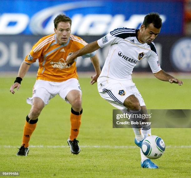 Juninho of the Los Angeles Galaxy keeps the ball away from Richard Mulrooney of the Houston Dynamo on April 10, 2010 in Houston, Texas.