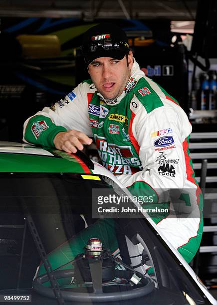 Elliott Sadler, driver of the Hunt Brothers Pizza Ford, climbs into his car during practice for the NASCAR Sprint Cup Series Samsung Mobile 500 at...