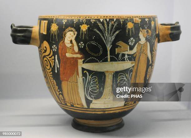 Pyxis depicting two women in a toilette next to a louterion. In the background, a bundle of grain. Made in Paestum. Apulian Group. 350-325 BC....