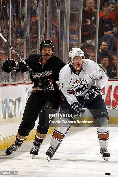 George Parros of the Anaheim Ducks defends against Tom Gilbert of the Edmonton Oilers during the game on April 11, 2010 at Honda Center in Anaheim,...