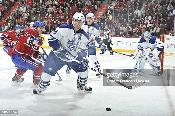 Francois Beauchemin of the Toronto Maple Leafs skates with the puck in front of Mathieu Darche of the Montreal Canadiens during the NHL game on April...