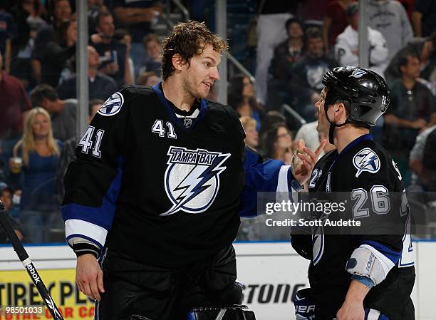 Goatlender Mike Smith of the Tampa Bay Lightning talks with teammate Martin St. Louis during a break in the action against the Ottawa Senators at the...