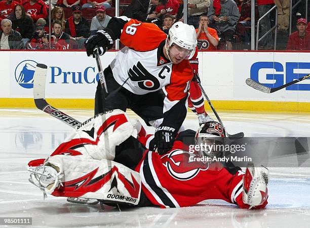 Mike Richards of the Philadelphia Flyers makes contact with goaltender Martin Brodeur of the New Jersey Devils in Game One of the Eastern Conference...