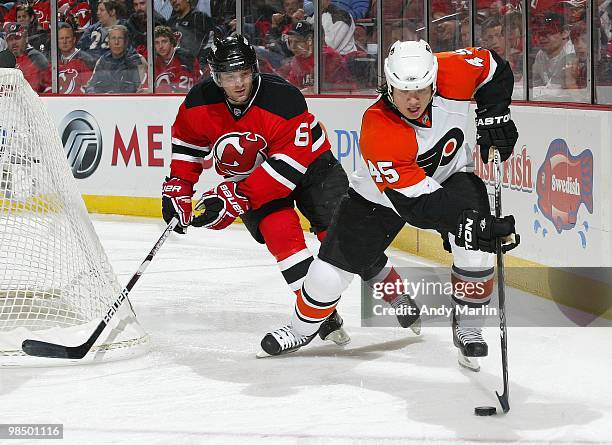 Arron Asham of the Philadelphia Flyers plays the puck against Andy Greene of the New Jersey Devils in Game One of the Eastern Conference...