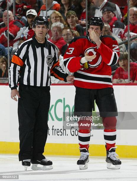 Referee Wes McAuley escorts David Clarkson of the New Jersey Devils as Clarkson holds his nose after being high sticked against the Philadelphia...