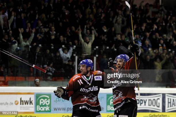 Christian Chartier of Augsburg celebrates his team's third goal with team mate Rhett Gordon during the fourth DEL play-off semi final game between...