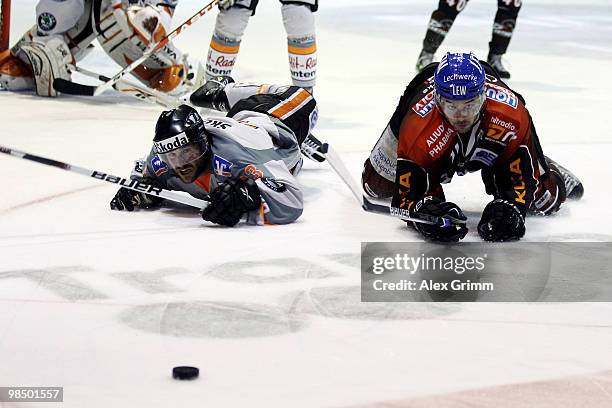 Blake Sloan of Wolfsburg and Colin Murphy of Augsburg look after the puck during the fourth DEL play-off semi final game between Augsburger Panther...