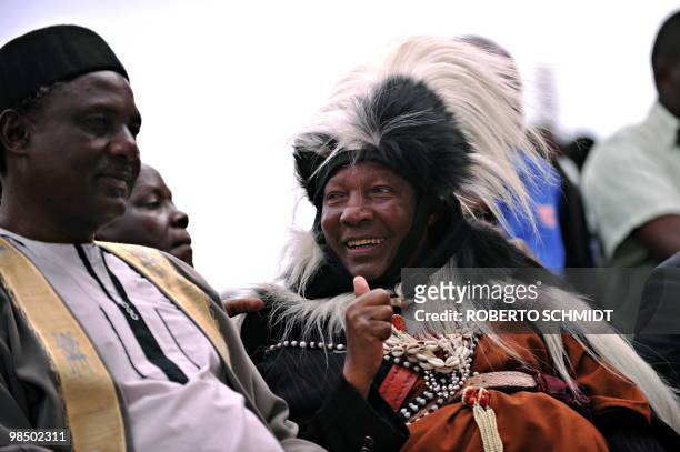 An elder from the Kenyan Kikuyu tribe smiles as he greets several Nigerian Kings during a ceremony in the western Ugandan town of Fort Portal for...