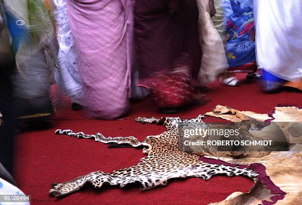 Special female guests wearing fancy traditional gowns sway near leopard and lion skins which adorn the seat used by King Oyo Nyimba Kabamba Iguru...