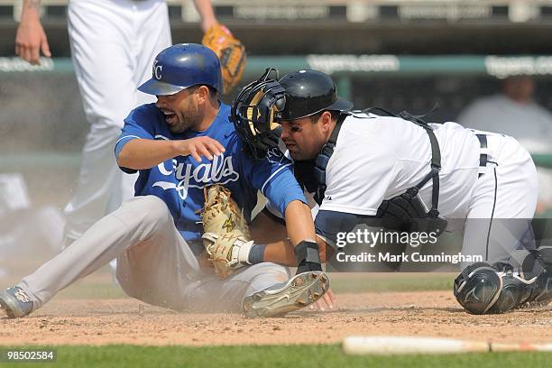 David DeJesus of the Kansas City Royals slides safely into home as Gerald Laird of the Detroit Tigers applies the tag during the game at Comerica...