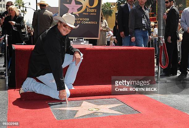 Country music performer Alan Jackson poses at his star on the Hollywood Walk of Fame at the star unveiling ceremony April 16, 2010 in the Hollywood...