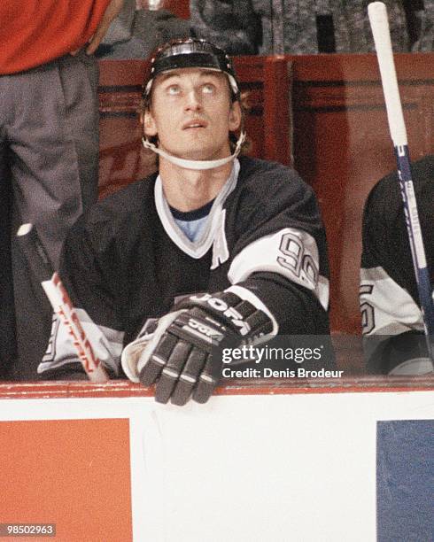 Wayne Gretzky of the Los Angeles Kings looks at the scoreboard while sitting on the bench during the game against the Montreal Canadiens in the...