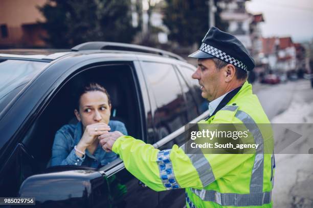 police man giving woman an alcohol test - sobriety test stock pictures, royalty-free photos & images