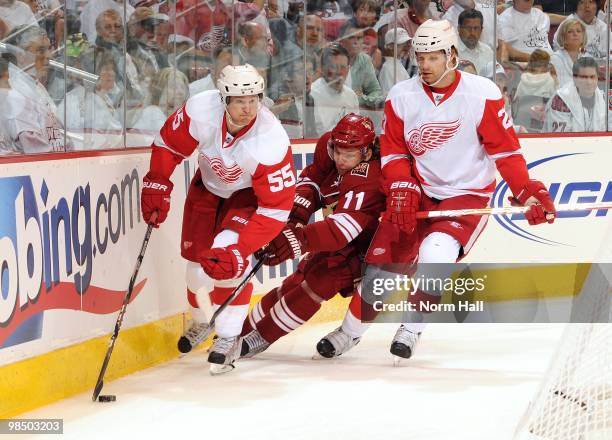 Martin Hanzal of the Phoenix Coyotes tries to skate between Niklas Kronwall and Brad Stuart of the Detroit Red Wings and steal the puck in Game One...