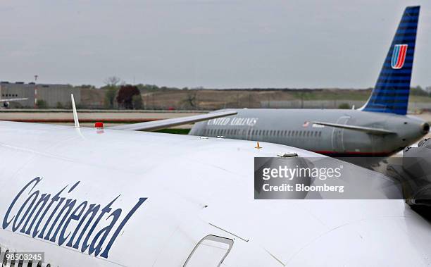 Continental Airlines jet, foreground, is parked near a passing United Airlines jet at O'Hare International Airport in Chicago, Illinois, U.S., on...