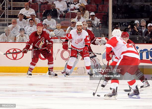 Derek Morris of the Phoenix Coyotes and Todd Bertuzzi of the Detroit Red Wings stand in front of Coyotes Goaltender Ilya Bryzgalov while watching the...