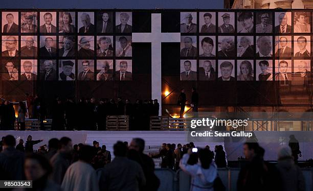 Visitors mill in front of a giant screen displaying photographs of the 96 people killed in the recent Polish presidential plane crash in Smolensk at...