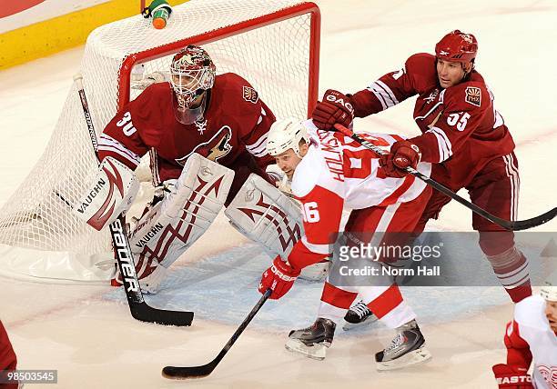Tomas Holmstrom of the Detroit Red Wings fights with Ed Jovanovski of the Phoenix Coyotes for position in front of Coyotes Goaltender Ilya Bryzgalov...