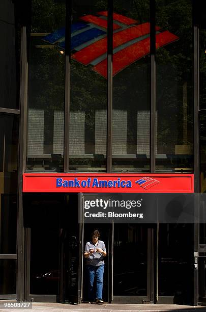 Customer walks out of a Bank of America Corp. Branch in Charlotte, North Carolina, U.S., on Friday, April 16, 2010. Bank of America Corp., whose...
