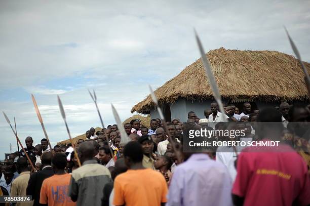 Residents of the western Ugandan village of Fort Portal watch as a delegation of the Toroo Kingdom carry ceremonial spears during the conmemoration...