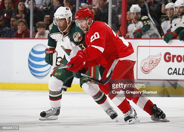 Robbie Earl of the Minnesota Wild battles for position with Drew Miller of the Detroit Red Wings during their NHL game on March 11, 2010 at Joe Louis...
