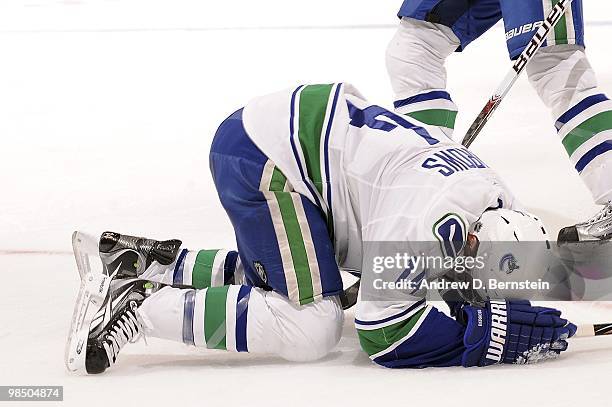 Alex Burrows of the Vancouver Canucks falls to the ice after being hit with a puck during the game against the Los Angeles Kings on April 1, 2010 at...