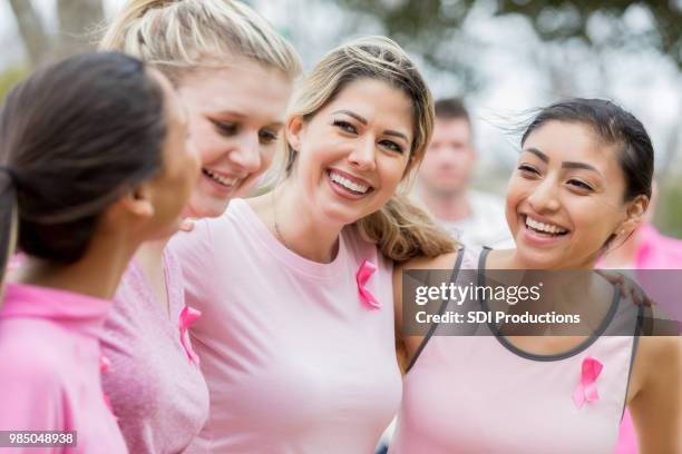 diverse frauen bei charity-spendenaktion - sensibilisierung für brustkrebs stock-fotos und bilder