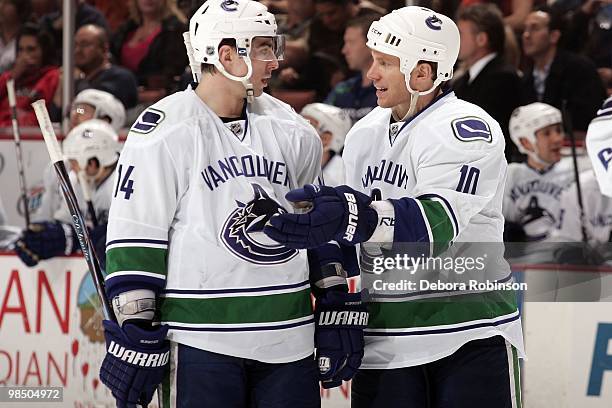 Alex Burrows and Ryan Johnson of the Vancouver Canucks talk on the ice during a break in action during the game against the Anaheim Ducks on April 2,...