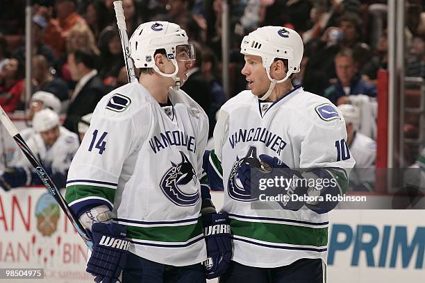 Alex Burrows and Ryan Johnson of the Vancouver Canucks talk on the ice during a break in action during the game against the Anaheim Ducks on April 2,...