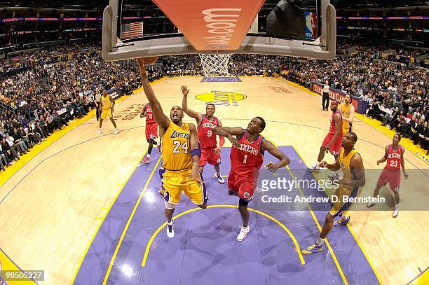 Kobe Bryant of the Los Angeles Lakers goes to the basket against Andre Iguodala and Samuel Dalembert of the Philadelphia 76ers during the game on...