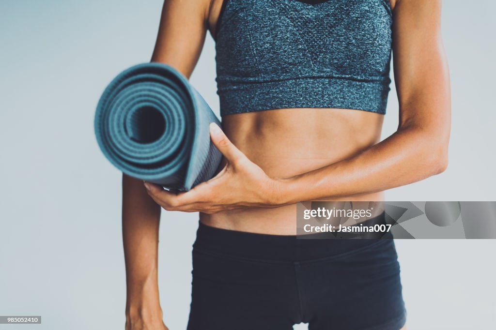 Healthy living- young woman with yoga mat