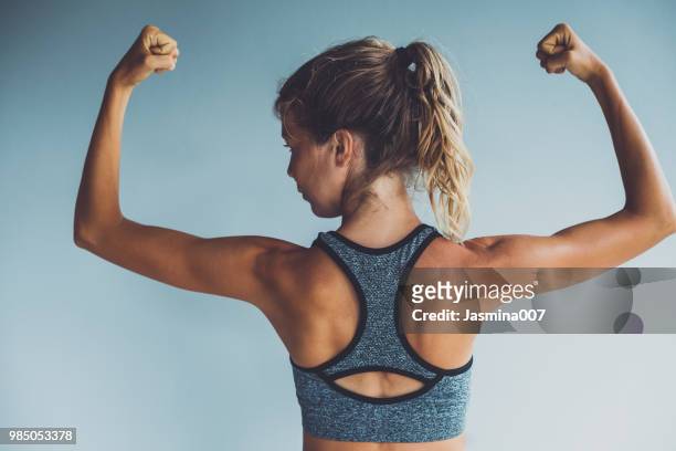 fitness woman flexing muscles - arm flexing stock pictures, royalty-free photos & images
