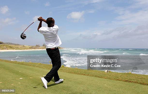 Usain Bolt tees up a golf ball as he drives it into the Caribbean Sea during the quarterfinal matches of The Mojo 6 Jamaica LPGA Invitational at...