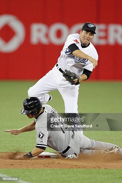 Gordon Beckham of the Chicago White Sox is forced out at 2nd base by John McDonald of the Toronto Blue Jays during their MLB game at the Rogers...